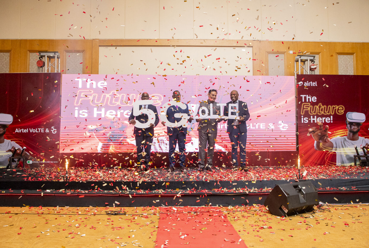 Four speakers celebrate the launch of Airtel's 5G and VoLTE services on stage, surrounded by confetti and vibrant decorations.