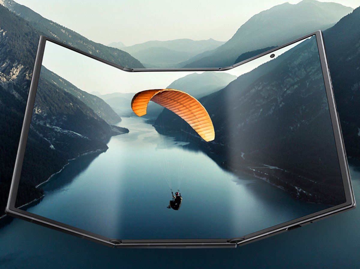 A paragliding scene displayed on a futuristic, curved screen with a scenic mountain and lake backdrop.